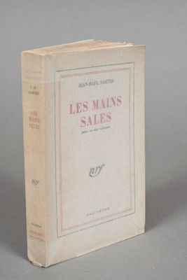 an old book sitting on top of a table on a gray surface