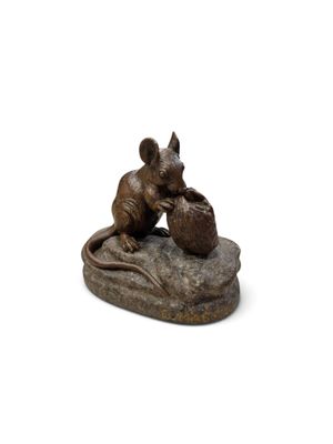 statue représentant une souris assise sur un rocher, tenant un panier de pommes