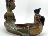 a ceramic figurine of a woman and a man in a boat