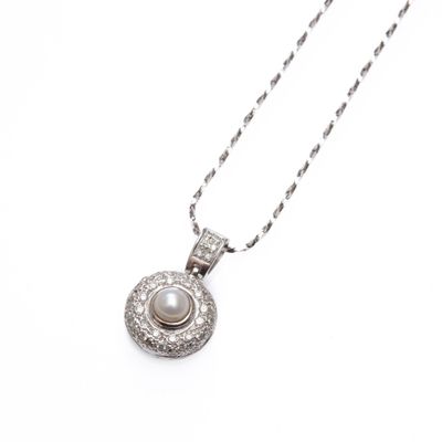 a close up of a necklace with a pearl on a chain