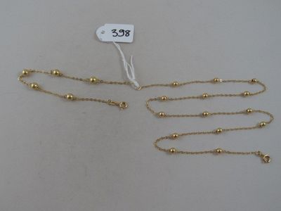 deux colliers plaqués or avec une étiquette de prix sur fond blanc