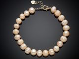 un bracelet de perles blanches avec un fermoir en or