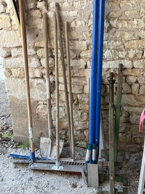 tout un tas de pelles appuyées contre un mur