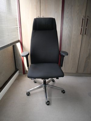 une chaise de bureau noire dans un coin de la pièce