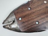 a fish shaped knife with a wooden handle on a white surface