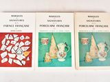 three books of french art and crafts on display on a white surface
