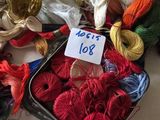 many different colored threads in a tin on a table