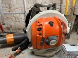 a chainsaw that is sitting on the floor next to other tools