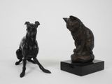 paire de sculptures en bronze représentant un chien et un chat, posées sur un socle noir