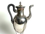 une théière en argent avec une anse noire sur fond blanc