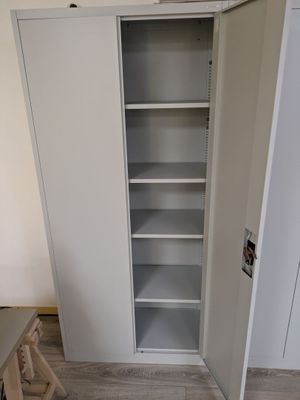 une photo d'un placard blanc avec des étagères dans une pièce
