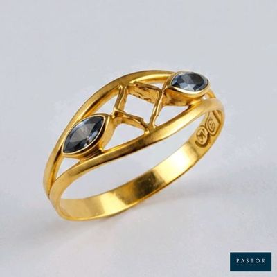 un gros plan d'une bague en or sertie de pierres noires