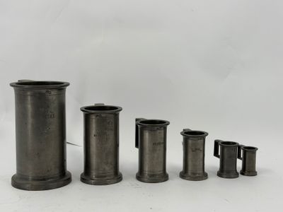 un ensemble de quatre vases en métal posés sur une surface blanche