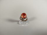 a close up of a ring with an orange stone on it
