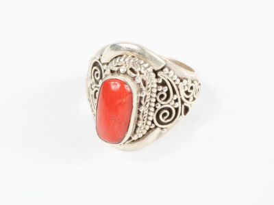 un gros plan d'une bague en argent sertie d'une pierre rouge