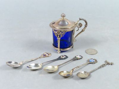 cinq cuillères et une théière sur la table
