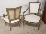 pair of antique chairs with upholstered arms and back cushions