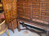 a large wooden cabinet with drawers and a chair in the room