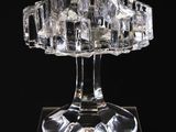 une image représentant une sculpture en verre transparent posée sur une surface noire