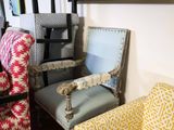 two chairs and a chair in a room with a painting on the wall