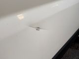 a small crack in the side of a white car