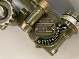 a close up view of a green fire hydrant with a compass