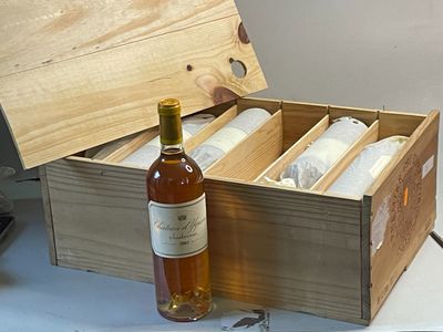 une bouteille de vin dans un coffret en bois à côté d'une bouteille de vin