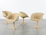 three chairs in a room with a white wall and concrete floor