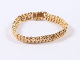 a close up of a gold bracelet on a white background