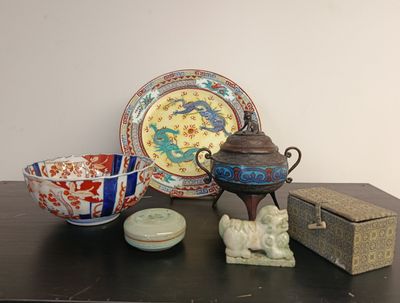 a table that has a bowl, a plate, and a teapot on it