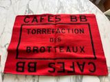 a red towel on a table that has a sign on it
