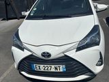 a white toyota yaris parked in a parking lot