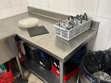 a kitchen with a sink, counter, and trash can in it