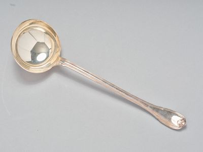 une cuillère en argent ornée d'un miroir, posée sur une table