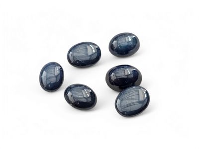 a set of five blue glass oval beads on a white surface