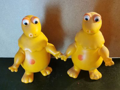 deux petits animaux en peluche jaunes qui sont debout l'un à côté de l'autre