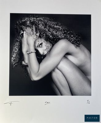photographie en noir et blanc d'une femme aux longs cheveux bouclés