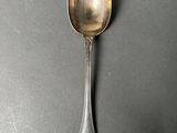 silver spoon on a table with a black background