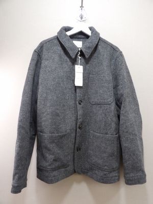 the jacket is hanging on a hanger on the wall