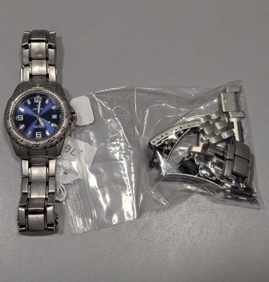 une montre posée sur une table à côté d'un sac en plastique