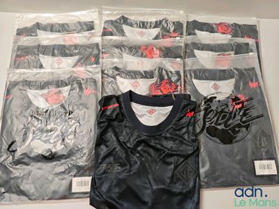 six paires de t-shirts noirs et blancs dans des sacs en plastique posés sur une table