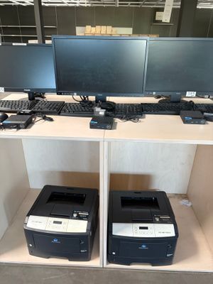 deux ordinateurs et une imprimante posés sur un bureau