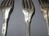 three forks that are sitting next to each other on a table