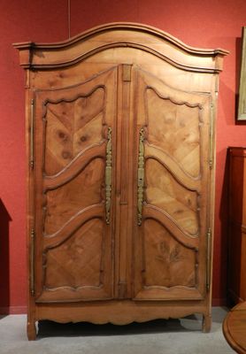 une armoire en bois dans une pièce où est accroché un tableau au mur