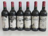 six bottles of wine are lined up in a row on a table