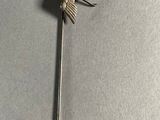 a silver pin with a bird on it on a table