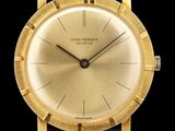 un gros plan d'une montre-bracelet plaquée or sur fond noir