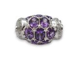 un gros plan d'une bague ornée de pierres violettes sur fond blanc