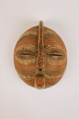un masque en bois accroché au mur