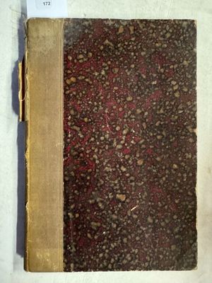 un vieux livre posé sur une table à côté d'un mur blanc
